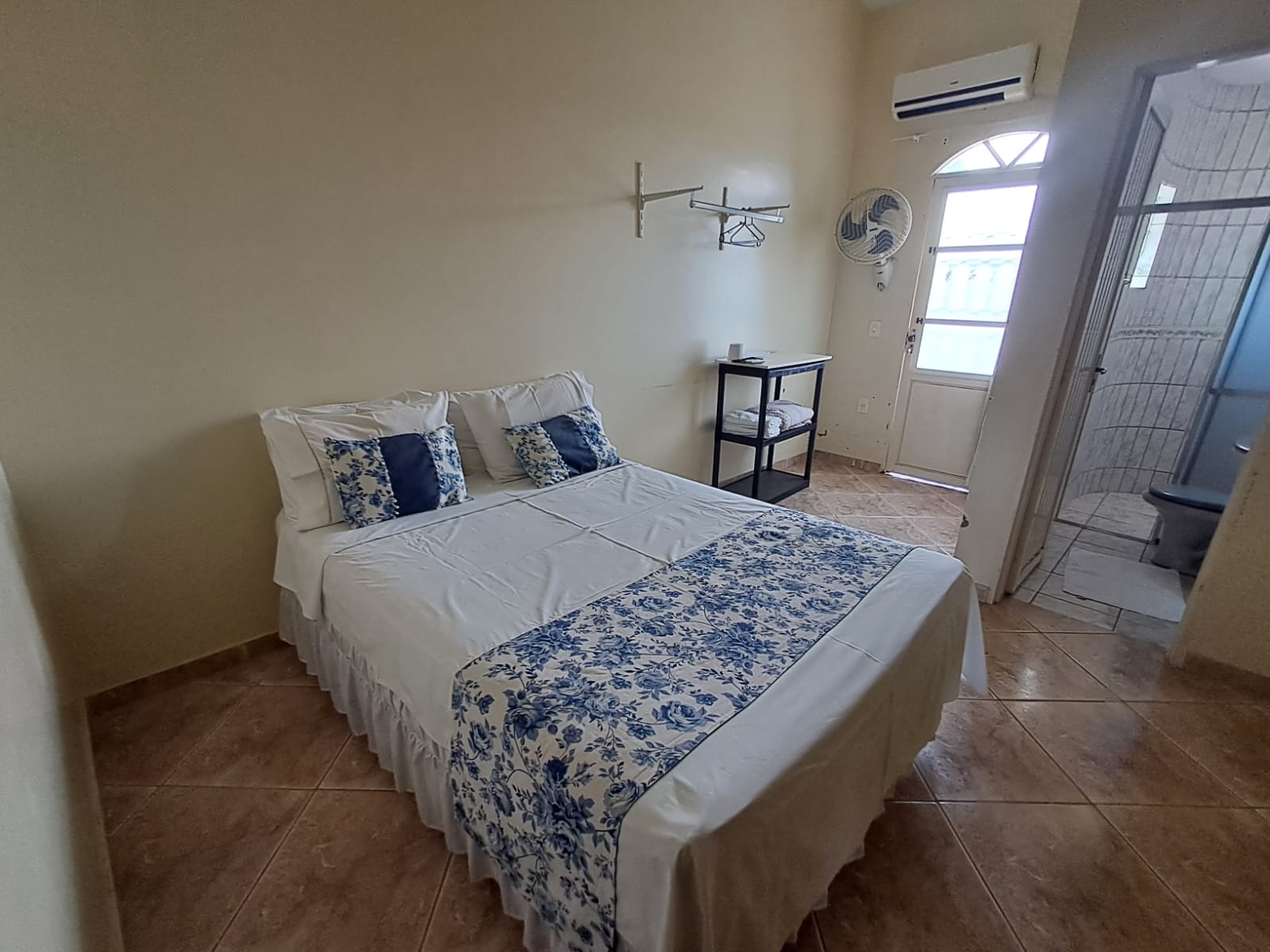 Cama de casal com roupa de cama azul e branca